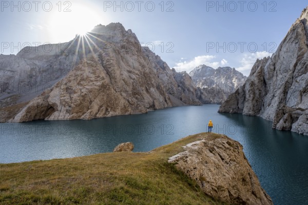 Tourist at the blue mountain lake between rocky steep mountain peaks, Sun Star, Kol Suu Lake, Sary Beles Mountains, Naryn Province, Kyrgyzstan, Asia