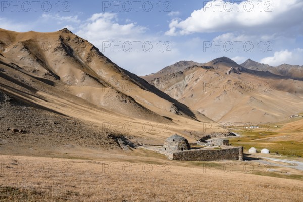Historic caravanserai Tash Rabat from the 15th century, with yellow hills, Atbashy district in the Naryn region, Kyrgyzstan, Asia