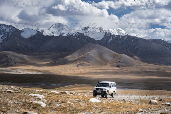 Off-road vehicle on a gravel track, glaciated and snow-covered peaks, Ak Shyrak Mountains, near Kumtor, Kara-Say, Tian Shan, Kyrgyzstan, Asia