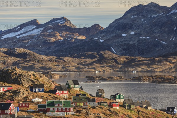 Typical Greenlandic houses on a fjord with steep mountains, Inuit settlement, autumn, Tasiilaq, East Greenland, Greenland, North America