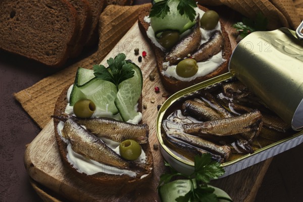 Sandwiches, black bread with sprats, cream cheese, cucumbers, on a cutting board, top view, close-up, no people