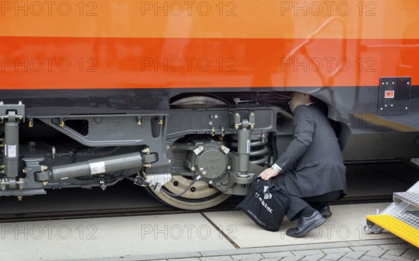 Chinese visitors to the InnoTrans trade fair in Berlin take a look at the undercarriage under a railway carriage, 20/09/2016
