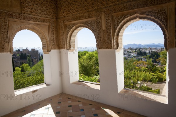Arched decorated Moorish stone windows looking over gardens, Generalife garden, Alhambra, Granada, Spain, Europe