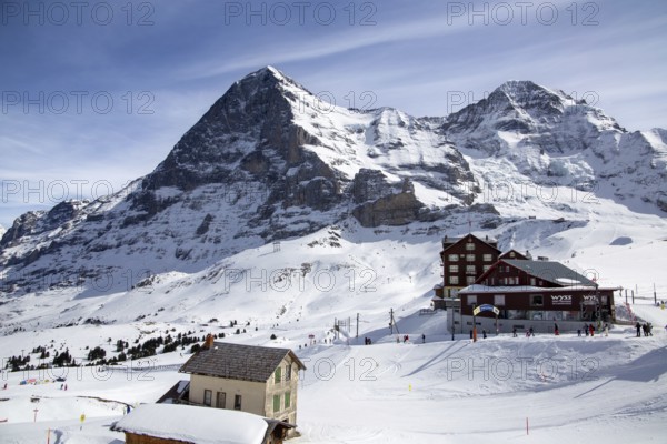 25 March 2024, Kleine Scheidegg, Grindelwald Switzerland : Many skiers and tourists enjoy the sunny winter weather. The famous north face of the Eiger in the background