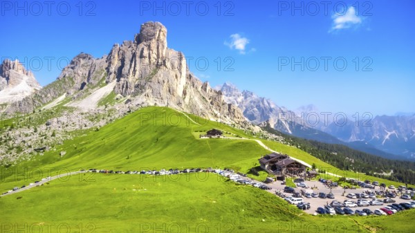 Panoramic view capturing the mountain shelter and parking area at passo giau in the italian dolomites on a sunny summer day