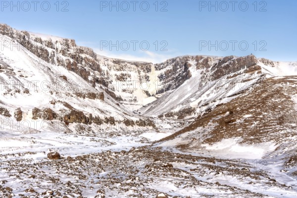 The beautiful Hengifoss waterfall frozen in the cold winter of Iceland, volcanic cliffs