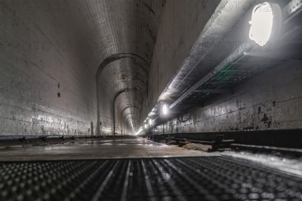 Concrete tunnel with long perspective to the inside, illuminated by lamps at the sides, humid environment, Rappbode Dam, Harz Mountains, Germany, Europe