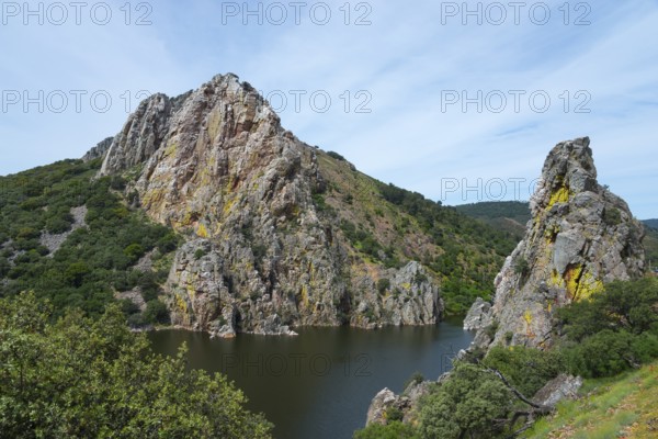 Large rock formations on the banks of a river under a blue sky, Salto del Gitano, River Tagus, Tagus, Monfragüe National Park, Cáceres, Caceres, Extremadura, Spain, Europe