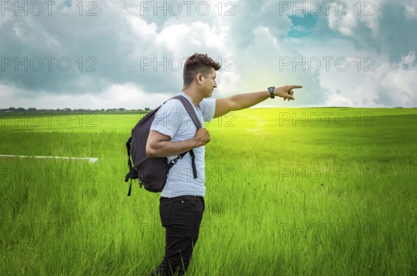 Adventurous man in the field, man with backpack in the field looking