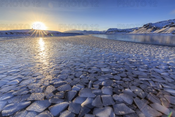 Ice floes on a lake in front of snowy mountains, sunset, backlight, snow, winter, Snaefellsnes, Vesturland, Iceland, Europe