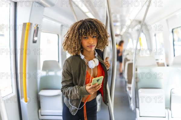 Portrait of a beauty latin young woman standing on the metro while using phone