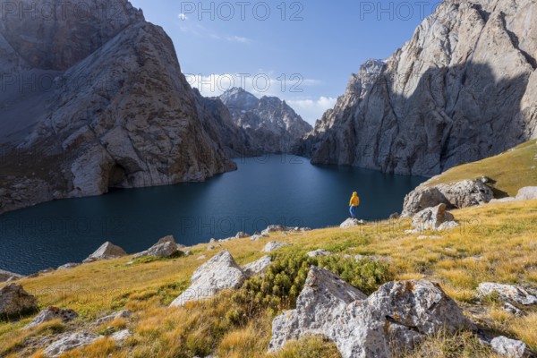 Tourist at the blue mountain lake between rocky steep mountain peaks, Kol Suu Lake, Sary Beles Mountains, Naryn Province, Kyrgyzstan, Asia