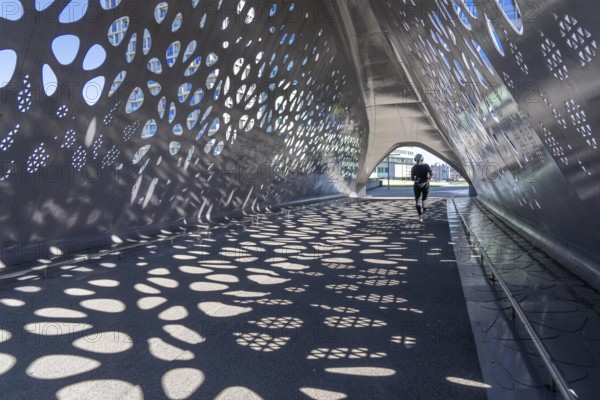 Light effects from the sun in the Parkbruk, a cycle and pedestrian bridge in the city centre of Antwerp, spanning a multi-lane city centre road with tram lines, and thus connecting two lively city districts Kop Spoor Noord and Eilandje, Belgium, without any crossings, Europe