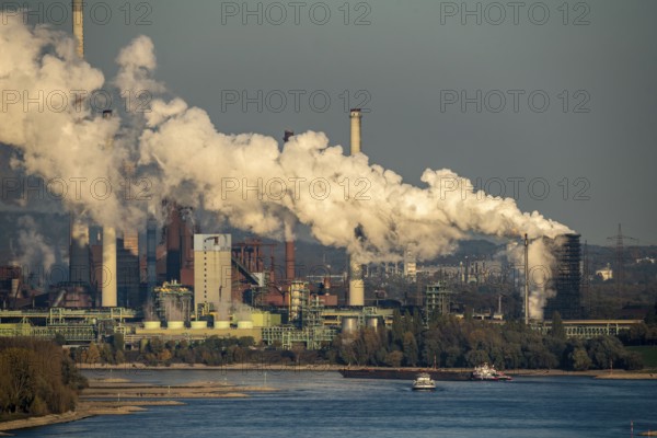 Rhine near Duisburg Bruckhausen, Thyssenkrupp Steel steelworks, blast furnaces, sintering plant, Schwelgern coking plant, discharge cloud, cargo ships, North Rhine-Westphalia, Germany, Europe