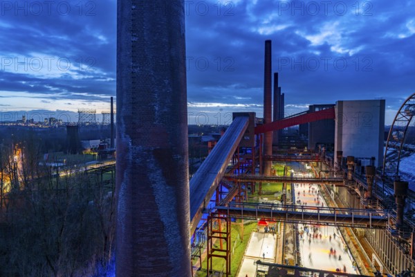 The ice rink at the Zollverein coking plant, Zollverein Coal Mine World Heritage Site, on the left the skyline of Essen city centre, North Rhine-Westphalia, Germany, Europe