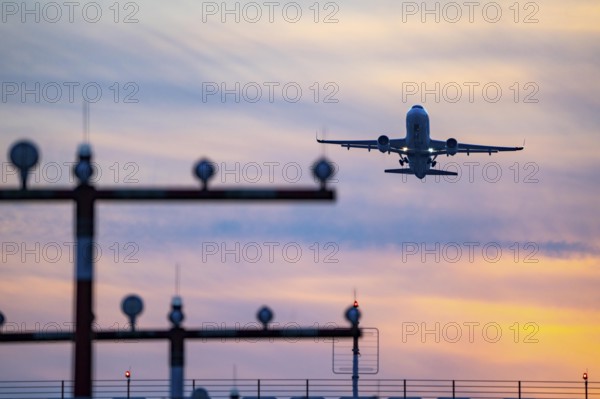Runway lighting, approach aids, at Düsseldorf International Airport, sunset, aircraft taking off from the main runway south, 05R/23L, North Rhine-Westphalia, Germany, Europe