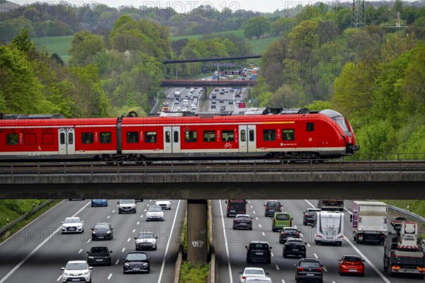 S-Bahn train crossing the motorway A3, traffic on 8 lanes, incl. the temporarily released hard shoulder, behind the motorway junction Hilden, view in north direction, near Erkrath, North Rhine-Westphalia, Germany, Europe