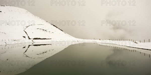 Onset of winter in May, Riezler Alpsee, an artificial lake, snow pond, feeds the snow cannons that provide the slopes of the Fellhorn and Kanzelwand cable cars with snow, Allgäu Alps, Vorarlberg, Austria, Europe