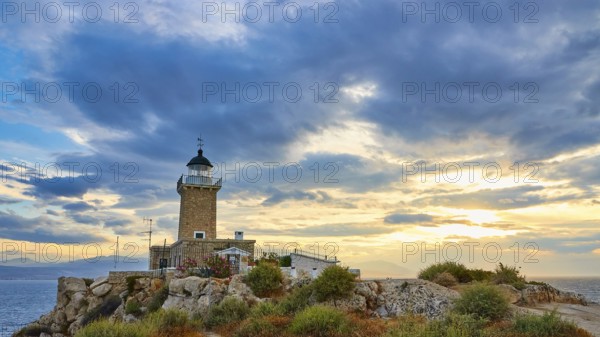 Lighthouse on rocks on the coast overlooking the sea during a picturesque sunset, lighthouse, Cape Melagkavi, Gulf of Corinth, Corinth, Peloponnese, Greece, Europe
