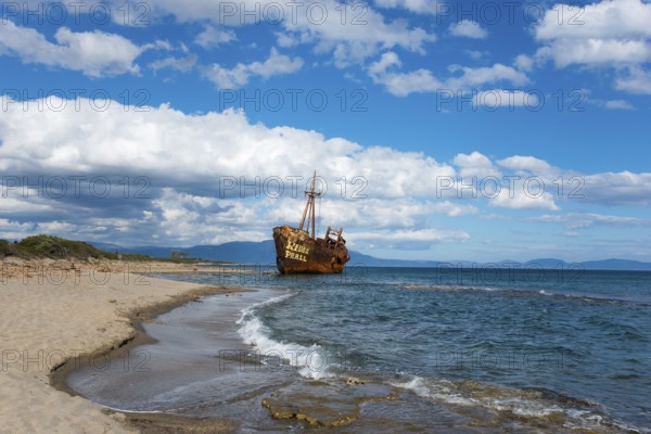 An abandoned, rusty shipwreck lies on a sunny beach with blue sky and clouds, Shipwreck Dimitrios, Glyfada Beach, Selinitsa, Gythio, Githio, Gythion, Mani, Laconia, Peloponnese, Greece, Europe