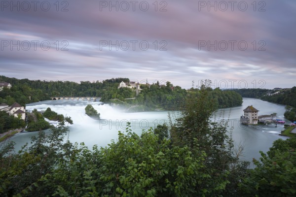 The Rhine Falls at Schaffhausen in Switzerland at sunset with Laufen Castle on the Rhine Falls. An extreme amount of water in 2024