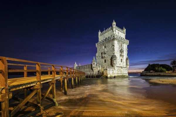 Belem Tower or Tower of St Vincent, famous tourist landmark of Lisboa and tourism attraction, on the bank of the Tagus River (Tejo) after sunset in dusk twilight with dramatic sky. Lisbon, Portugal, Europe