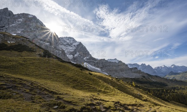 Mountain landscape with yellow meadows in autumn, summit Lamsenspitze with sun star, Karwendel, Tyrol, Austria, Europe