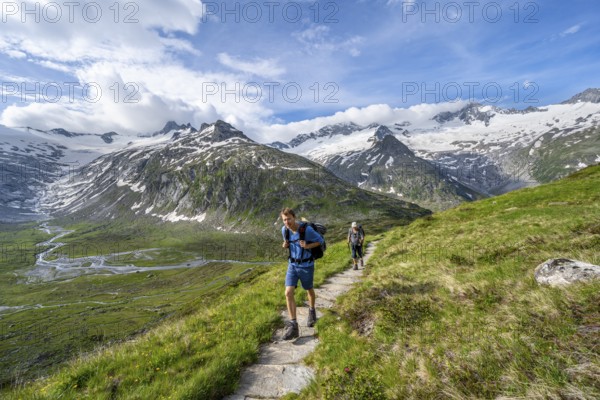 Two mountaineers on hiking trail in picturesque mountain landscape, mountain peak with snow and glacier Schwarzensteinkees, Hornkees and Waxeggkees, summit Schwarzenstein, Hornspitzen and Turnerkamp, valley Zemmgrund with Zemmbach, Berliner Höhenweg, Zillertal Alps, Tyrol, Austria, Europe