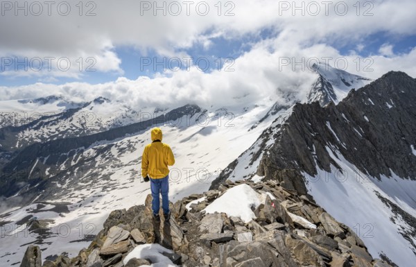 Mountaineer at the summit of the Schönbichler Horn, view of snow-covered mountain landscape with glaciated summit Großer Möseler, Berliner Höhenweg, Zillertal Alps, Tyrol, Austria, Europe