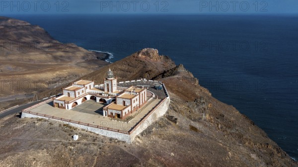 Bird's eye view of aerial view of building complex of lighthouse Faro de la Entallada from 50s year 1953 1954 with large glass dome on 183 metres high cliff, behind it steep coast and Mirador de Entallada, Las Playitas, Tuineje, Las Palmas, Fuerteventura, Canary Islands, Spain, Europe