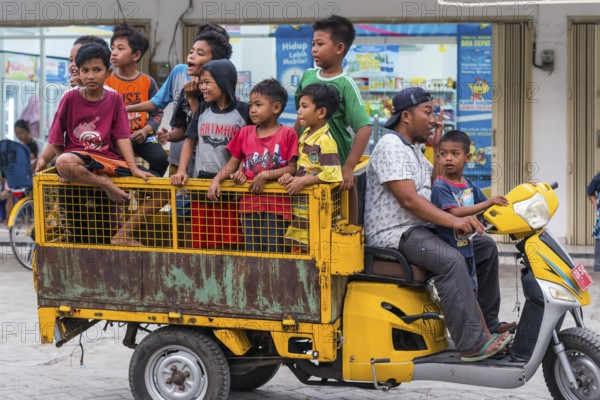 Children on a vehicle in an Indonesian village, village, child, boy, curious, curiosity, childhood, carefree, lifestyle, village life, street scene, Asian, authentic, locals, tradition, traditional, travel, tourism, culture, poverty, person, Lombok, Indonesia, Asia
