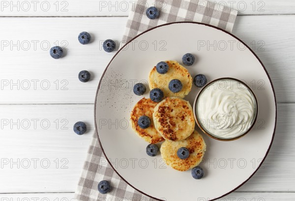 Cottage cheese pancakes, with blueberries, breakfast, on a white wooden table, no people, top view