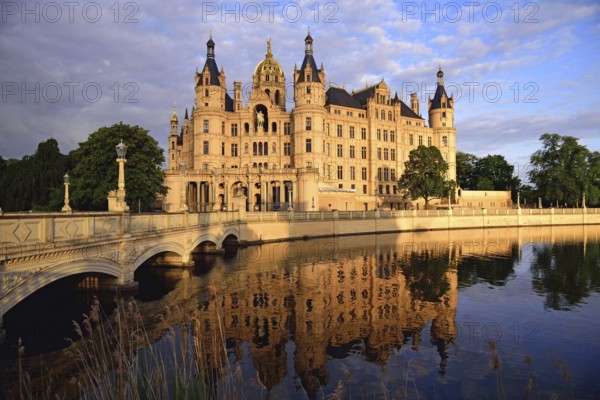 Europe, Germany, Mecklenburg-Western Pomerania, Schwerin, Schwerin Castle, built 1845 to 1857 in the style of romantic historicism, today seat of the state parliament, front with bridge to the castle island, evening light, Schwerin, Mecklenburg-Western Pomerania, Germany, Europe