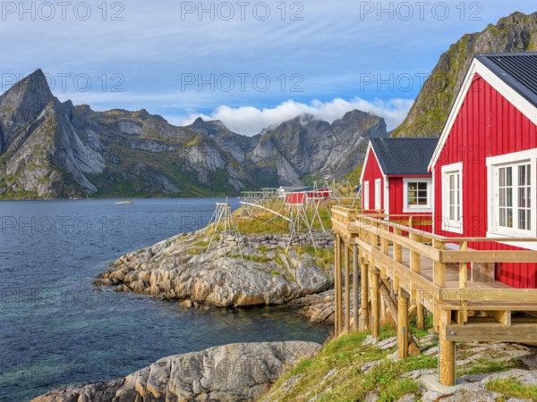 Rorbuer in Hamnoy in front of the mountain Olstinden, blue sky, Moskenesoya, Lofoten, Norway, Europe