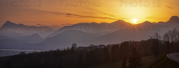 Sunset over a silhouetted mountain landscape, the sky glows in orange tones as dusk sets in, Praschberg, Austria, Europe