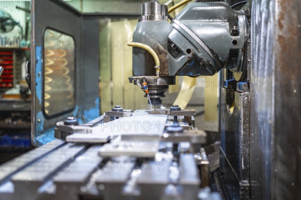 Milling machine molding shapes in metal pieces in a cnc factory with no people