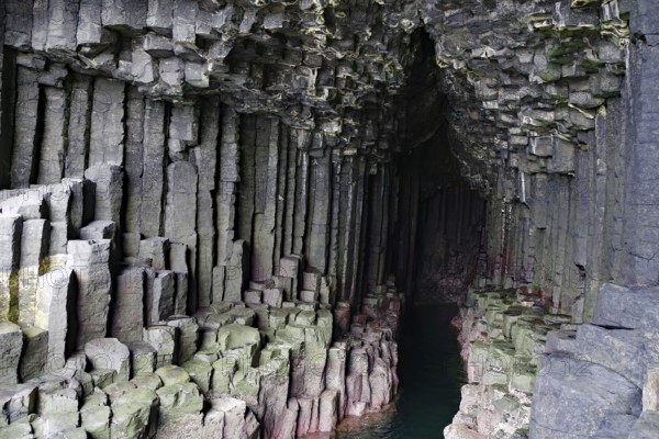 Dark cave with impressive basalt columns and deep water in a natural setting, Staffa, Inner Hebrides, Scotland, United Kingdom, Europe