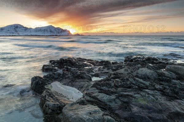 Long exposure, sunset in winter at Skagsanden, rocks on the beach at Flakstad, Flakstadøy, Lofoten, Nordland, Norway, Europe