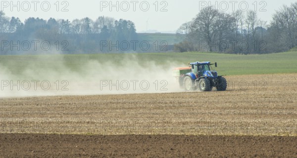 Spring farming, spreading fertilizer with tractor on field in Ystad municipality, Skåne county, Sweden, Scandinavia, Europe