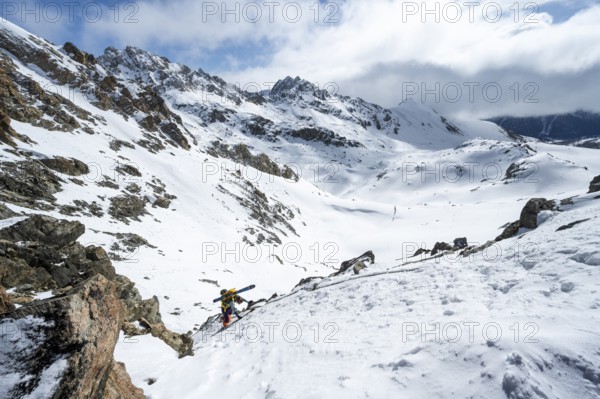 Mountaineer with skis climbing up a steep snow slope to the fork Porta d'Es-cha, ski tour Bündner Haute Route, Albula Alps, Rhaetian Alps, Grisons, Eastern Switzerland, Switzerland, Europe