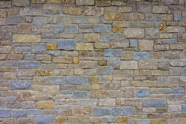 Wall of colourful natural stones in shades of blue and beige with uneven texture, Würzburg, Bavaria, Germany, Europe