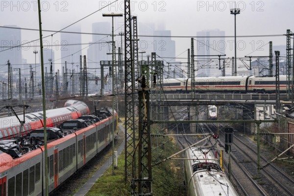 Railway tracks with regional and long-distance trains, ICE, after freezing rain, in front of Frankfurt main station, skyline in the fog, Hesse, Germany, Europe