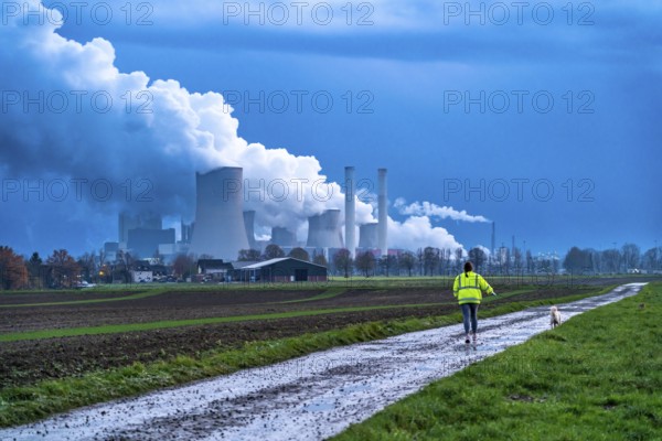 Field path, woman walking her dog, lignite-fired power plant, RWE Power AG Niederaußem power plant, near Bergheim, North Rhine-Westphalia, North Rhine-Westphalia, Germany, Europe