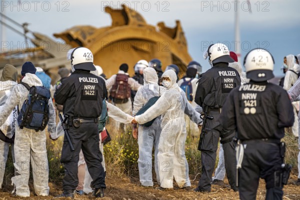 Protest action against the demolition of the village of Lützerath in the Rhenish lignite mining area, which is to make way for the expansion of the Garzweiler II open-cast mine, activists wanted to occupy an excavator, but were stopped by the police at the edge of the spoil heap, Lützerath, North Rhine-Westphalia, Germany, Europe