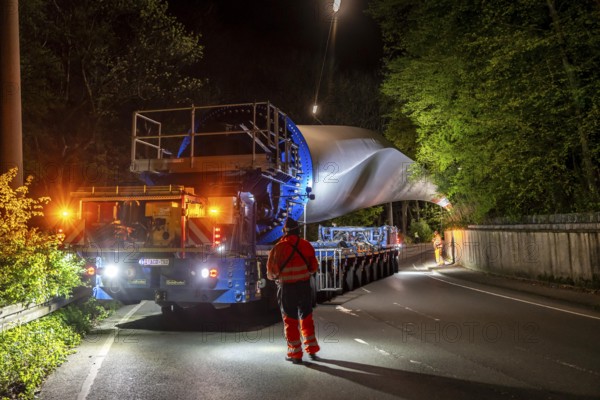 Transport of a 68 metre long, 22 tonne blade of a wind turbine, here in Schwelm, with a self-propelled Blade-Lifter vehicle, over a 40 km long route, over 2 nights, in the Bergisches Land, through towns, villages, over country roads, narrow through roads, to the construction site of the wind turbine near Hagen, North Rhine-Westphalia, Germany, Europe