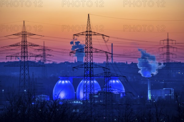 Digesters of the Emscher sewage treatment plant Bottrop, illuminated, high-voltage pylons, North Rhine-Westphalia, Germany, Europe