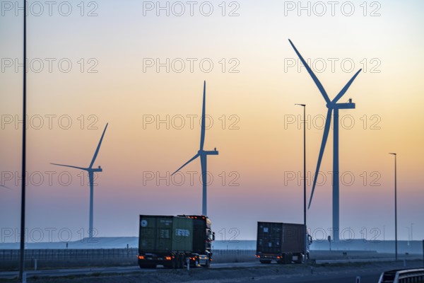 Lorry on the road from Euromax Terminal Rotterdam, ENECO wind farm on the dike around the port of Maasvlakte 2, 22 wind turbines with a capacity of 116 megawatts, sunset, Rotterdam, Netherlands