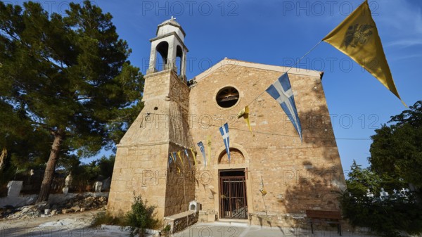 Church entrance with bell tower and Greek flags under a bright blue sky, Koroni, Byzantine fortress, nunnery, Peloponnese, Greece, Europe
