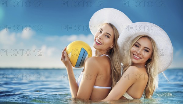 Two young woman in sun hats playing with a beach ball on the beach in the Caribbean