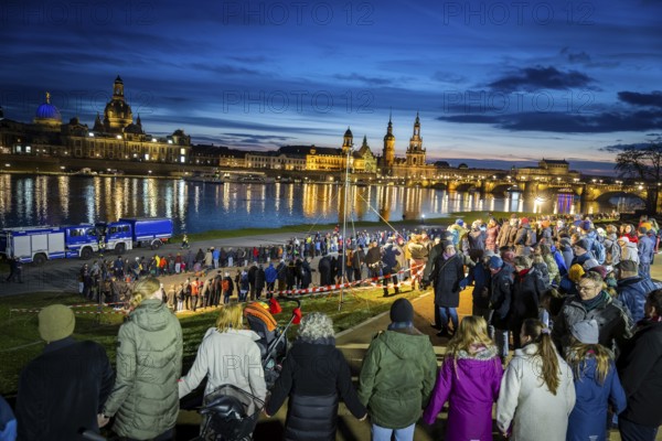 On 13 and 14 February 1945, Dresden was heavily destroyed in three Allied bombing raids. Every year, the people of Dresden commemorate this event at various events. A long human chain symbolised the protection of the city centre. Here looking from the Königsufer across the Elbe to the Old Town, Dresden, Saxony, Germany, Europe